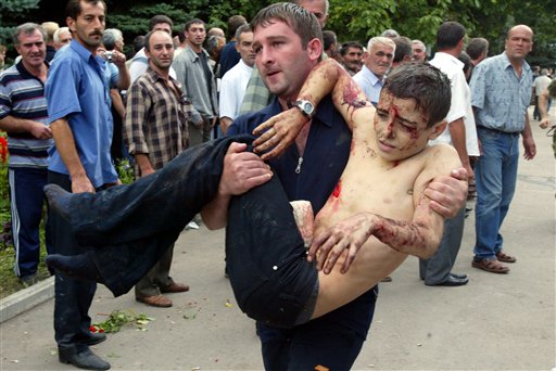 A wounded boy is carried after he escaped from a school in Beslan, Northern Ossetia, Russia Friday, Sept. 3, 2004. (AP)