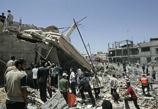 Palestinians gather by a building destroyed in an explosion in the town of Beit Lahiya, northern Gaza. (AP)