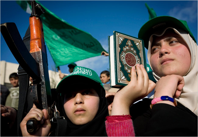 A Palestinian girl holds a Koran and a fake rifle at a recent rally organized by Hamas in Gaza. (New York Times)
