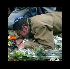 Man hugging the grave of a murdered loved one in Israel.