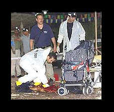 Rescue worker cleaning blood near baby carriage at site of terrorist blast in Israel.