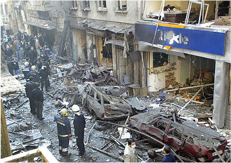 Turkish police officers examine the scene in front of the Neve Shalom Synagogue after Saturday's car bomb attack.  Neve Shalom was crowded for a bar mitsvah celebration.